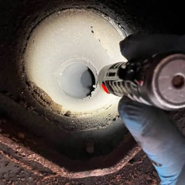 Interior of a swept flue, lit and clean, with the vacuum hose in shot