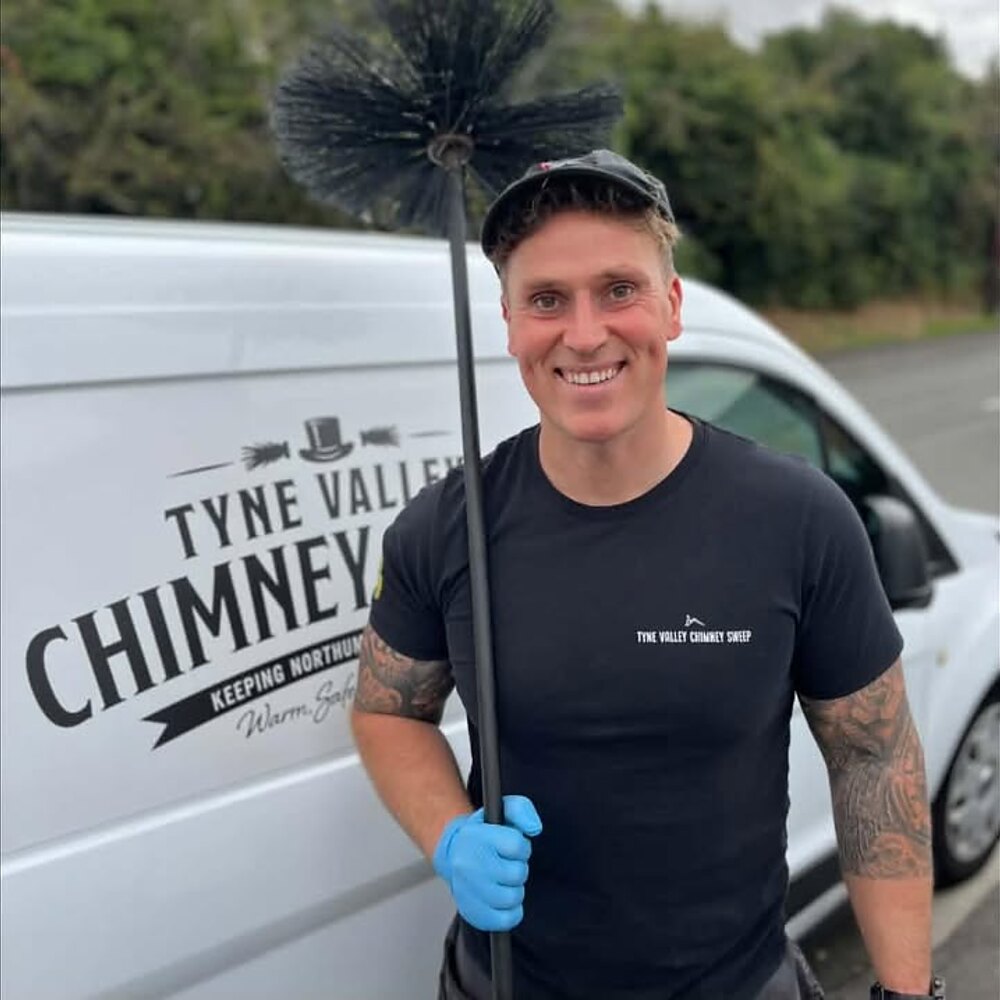 Tommy Wanless with a sweep brush beside the Tyne Valley Chimney Sweep van